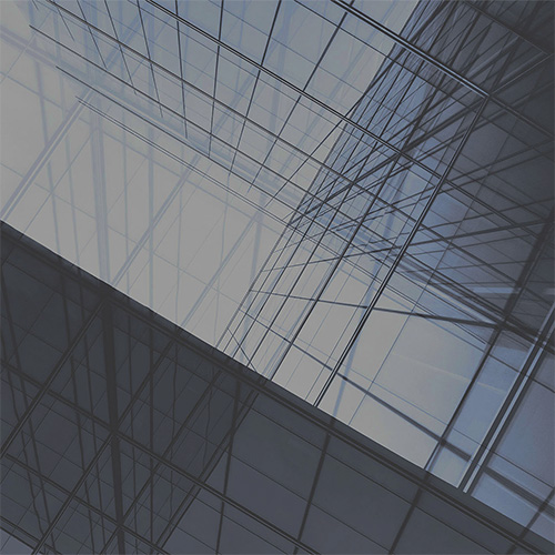 Why EAM Works Better as a Digital Twin for Enterprises. Abstract upward view of a modern glass building with intersecting reflective panels in blue and gray.