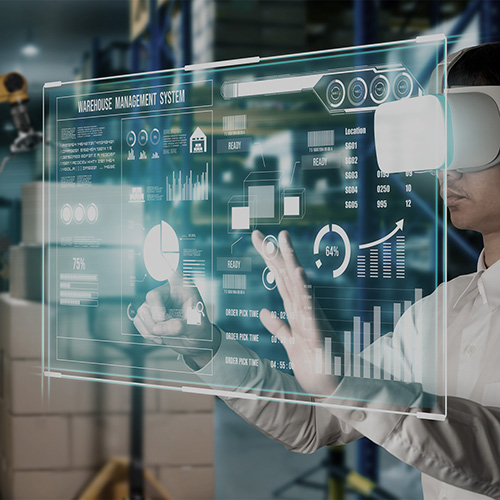 Revamping Warehousing Through Gamification. Warehouse worker using virtual reality and augmented touchscreen interface for warehouse management with robotic arms in a smart automated warehouse.