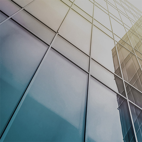 Upgrading to LeanIX Metamodel 4. Upward view of a modern glass building with reflective windows and geometric patterns.