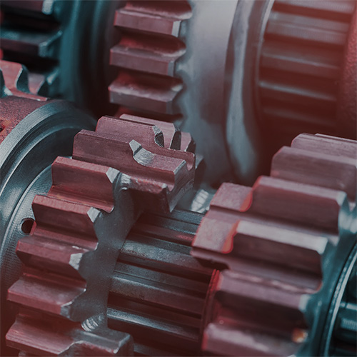 How Multi-Echelon Inventory Boosts Spare Parts Planning. Close-up of interlocking metal gears representing mechanical engineering, spare parts planning, and industrial supply chain optimization.